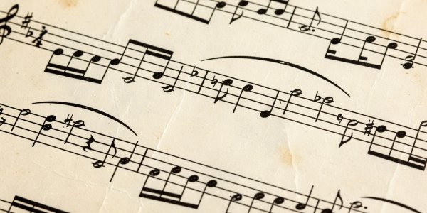 A close up of printed musical notes and dynamic markings on a vintage score